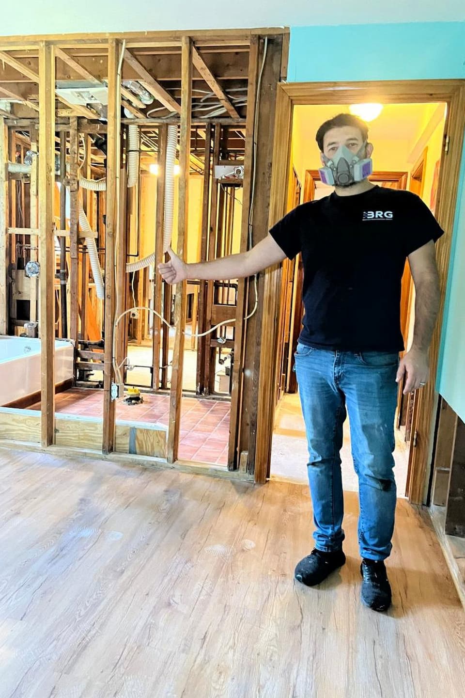 BRG technician wearing respiratory protection at an opened residential work area