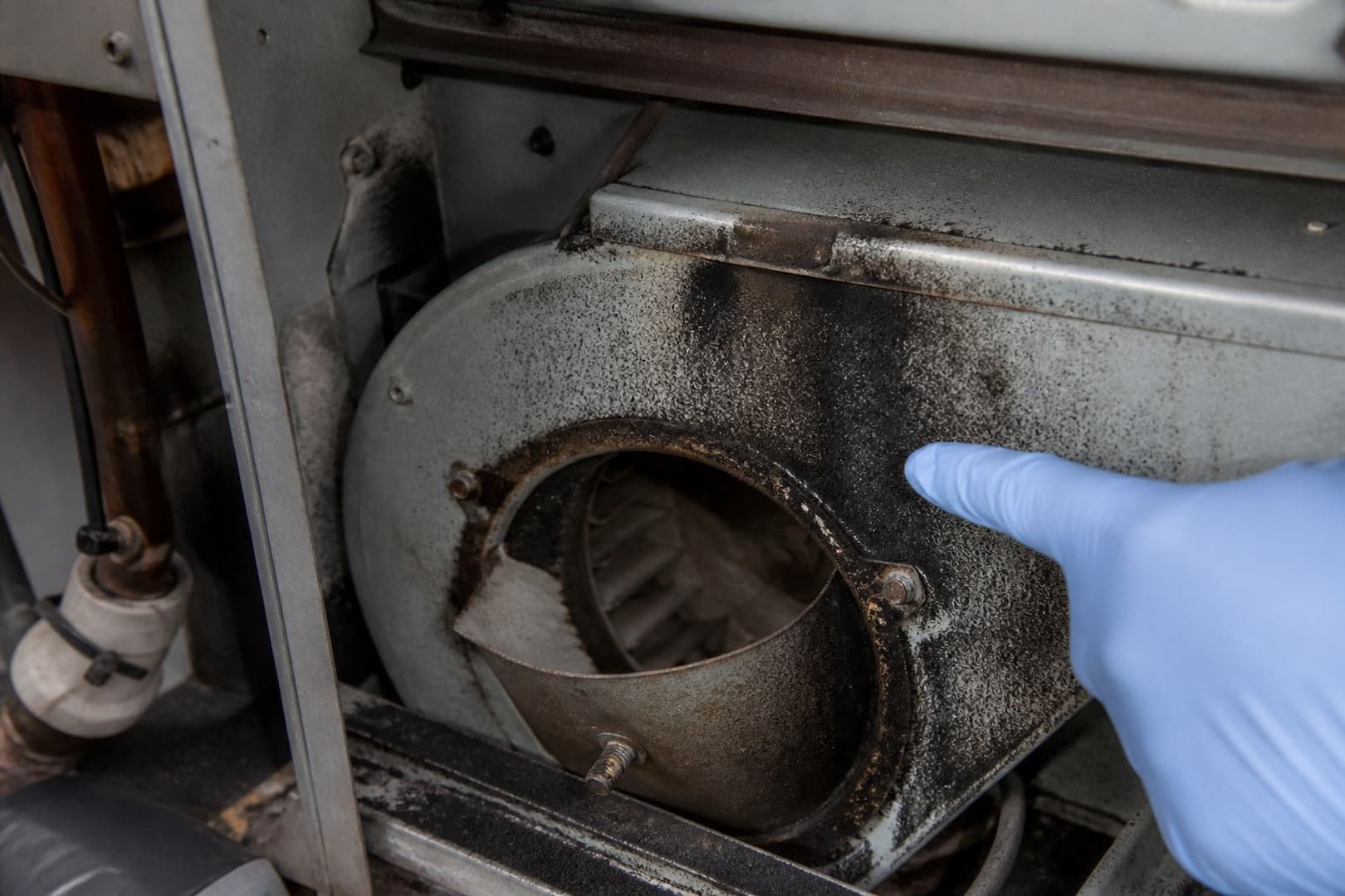 BRG fire and soot restoration technician inspecting oily residue after a furnace puffback — close technical detail