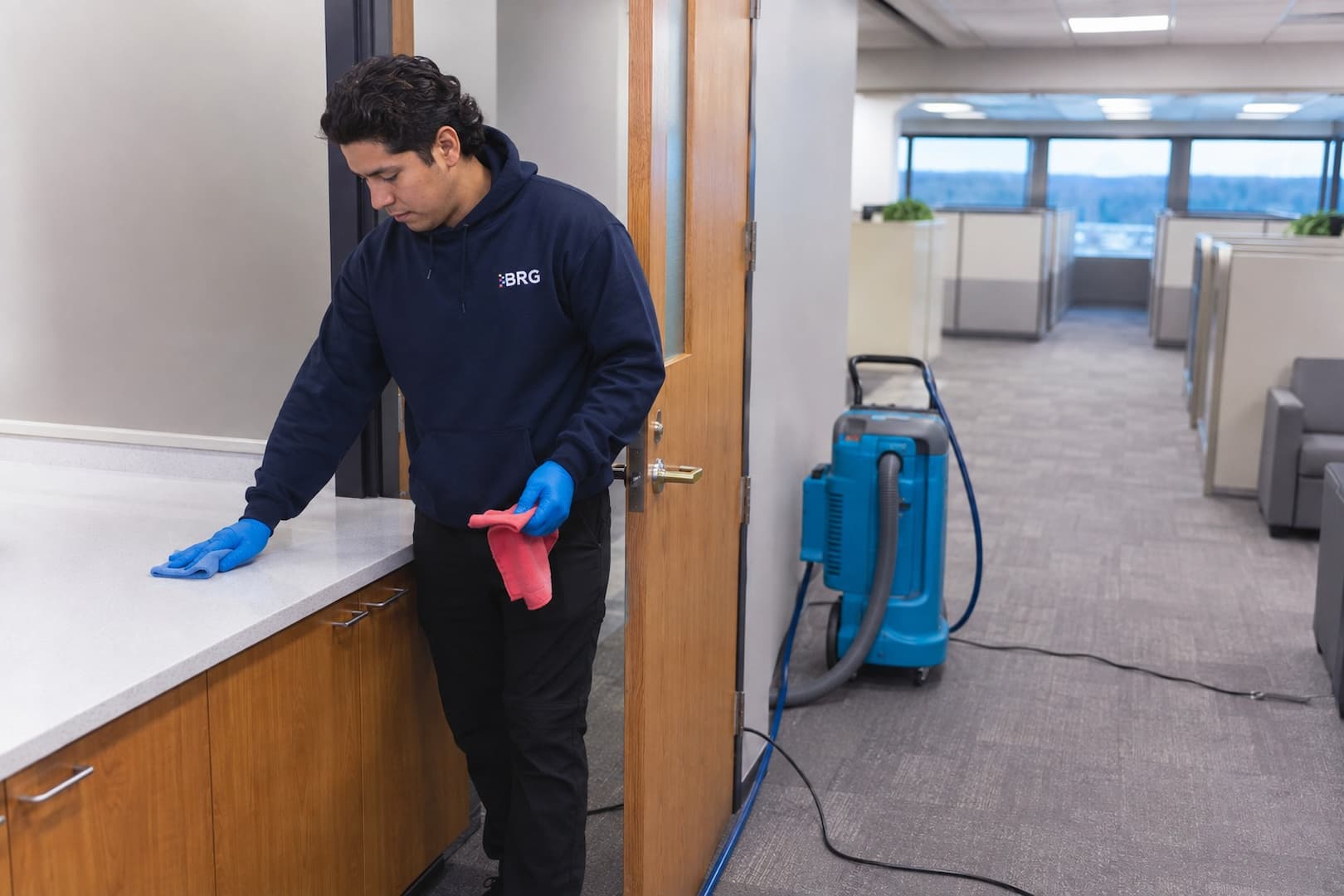 Technician cleaning high-touch surfaces before disinfection