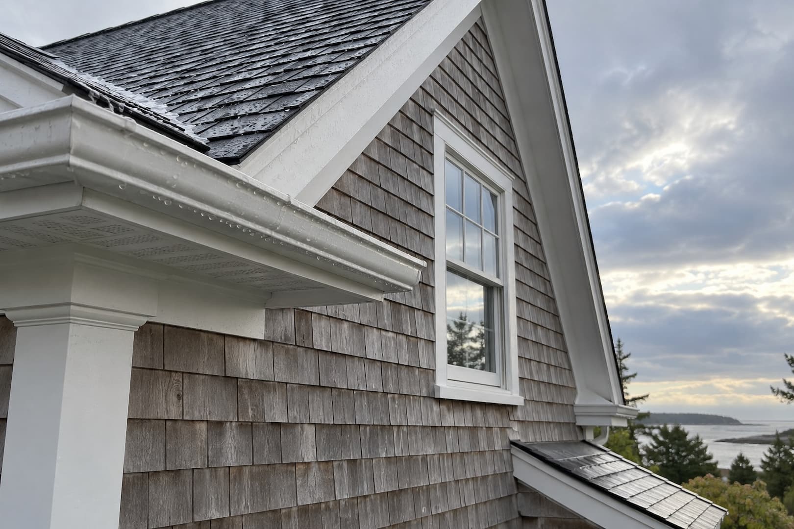 Rain-wet cedar siding and roof eaves on a coastal New England house